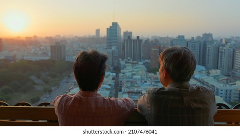 Back View Of Senior Asian Couple Looking Outside From Home