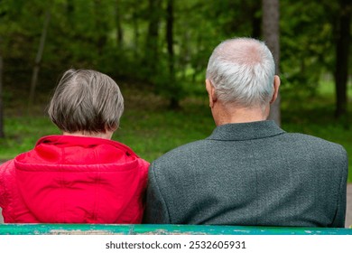 Back view of a senior couple sitting on a bench in the park. Elderly couple. - Powered by Shutterstock