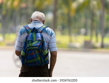 Back View Of A Senior Man Looking At The Phone To Find A Way Out.