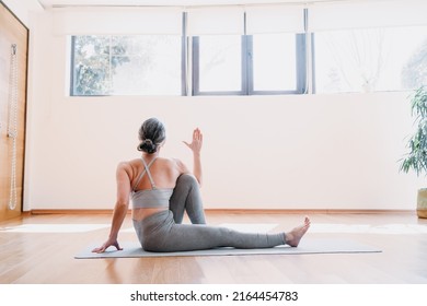 Back View Of The Senior Woman Practicing Yoga, Doing Half Lord Of The Fishes Exercise. Lady Sitting In Yoga Posture And Having Morning Meditation At Home. Physical And Spiritual Practice Concept