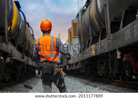 back view service worker with freight train oil transport on background.