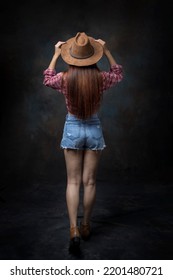 Back View Of Sexy Blonde Long Hair Woman Cowgirl In Studio.