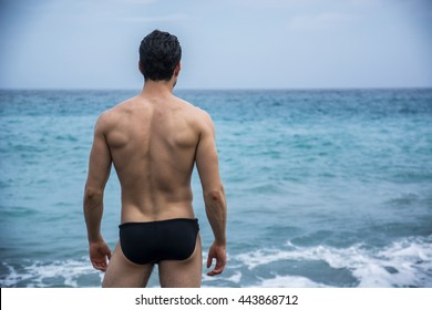 Back View Of Sexy Unrecognizable Man In Trunks On Beach Against Of Sea