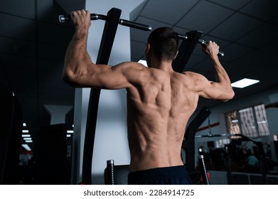 Back view of shirtless man with pull-ups in gym.  - Powered by Shutterstock