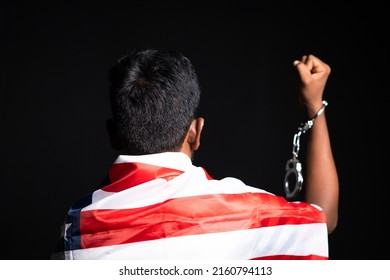 Back View Shot Of Man With Us Or American Flag On Shoulder Showing Hands With Released Cuffs On Black Background