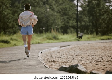 Back view shot of unrecognizable woman running away on wooden path - Powered by Shutterstock