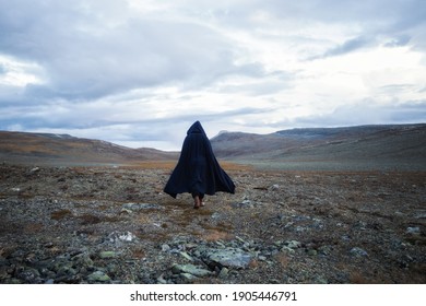 Back view silhouette of male traveler in medieval clothes. Man is walking through the mountains on the background of the dramatic cloudy sky.
 - Shutterstock ID 1905446791