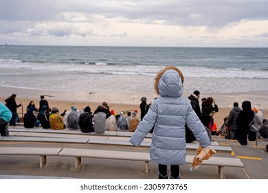 Back view of small child at sea shore waiting to see penguin parade.                              - Powered by Shutterstock