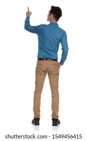 Back View Of Smart Casual Man Looking Up And Pointing Finger, Standing Isolated On White Background, Full Body