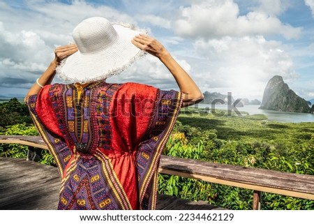 Back view of solo traveler woman enjoying Phang Nga bay view point, relaxing. Tourist at Samet Nang She, Thailand. Asia travel, trip and summer vacation concept.