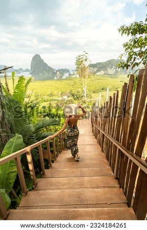Back view of solo traveler woman enjoying Phang Nga bay view point, walking and relaxing. Tourist at Samet Nang She, Thailand. Asia travel, trip and summer vacation concept.