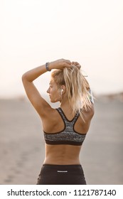 Back View Of Sportswoman Making Ponytail.