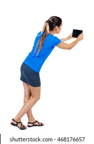 Back View Of Standing Young Beautiful  Woman  Using A Mobile Phone. Girl  Watching. Rear View People Collection.  Backside View Of Person.  Isolated Over White Background. Girl In A Short Skirt And A