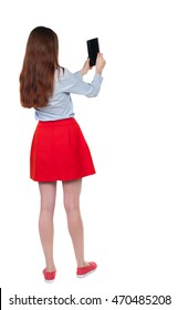 Back View Of Standing Young Beautiful  Woman  Using A Mobile Phone. Girl  Watching. Rear View People Collection.  Backside View Of Person.  Isolated Over White Background. Long-haired Brunette In Red