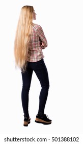 back view of standing young beautiful  woman.  girl  watching. Rear view people collection.  backside view of person.  Girl with very long hair standing with his arms crossed.