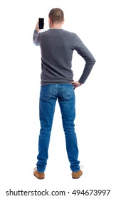 Back View Of Standing Young Man  And Using A Mobile Phone. Girl Watching. Rear View People Collection.  Backside View Of Person.  Isolated Over White Background. A Guy In A Gray Sweater Photographed