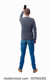 Back View Of Standing Young Man  And Using Mobile Phone. Girl Watching. Rear View People Collection. Backside View Person. Isolated Over White Background. Guy In A Gray Sweater Photographs Smartphone