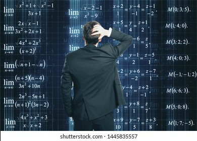 Back view of stressed young businessman looking at mathematical formulas on dark background. Programming, science, knowledge and complex algorithm concept - Powered by Shutterstock