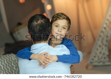 Back view of strong man that embracing son