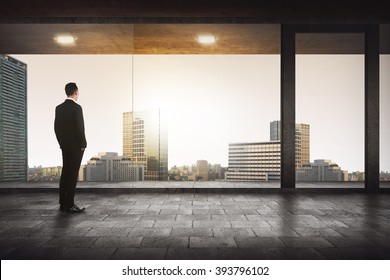 Back view of successful manager looking the city from his office - Powered by Shutterstock