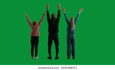 Back view of a team of three hikers raising their hands in the air, making a gesture of victory. A group of people rejoicing and cheering in a studio on a green screen. Travel concept. - Powered by Shutterstock