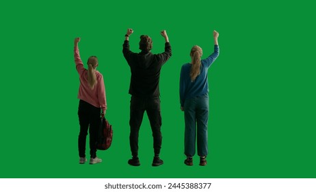 Back view of a team of three hikers raising their hands in the air, making a gesture of victory. A group of people rejoicing and cheering in a studio on a green screen. Travel concept. - Powered by Shutterstock