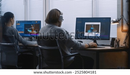 Back view of team of workers using AI generator on computers in office. PC screens showing artificial intelligence chatbot generating text prompt to realistic photo or video content. Automated artwork