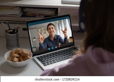 Back View Of Teen Girl Sit At Desk Listen To Teacher Talking, Have Online Web Lesson Or Class On Computer At Home, Schoolgirl Study Distantly, Engaged In Webcam Conference Or Video Call With Tutor