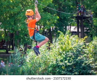 Back view with a teen young adult riding a zip line in Comana Adventure Park, Romania. - Powered by Shutterstock