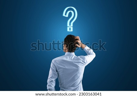 Back view to a thoughtful businessman and a question mark on his head on a dark blue background, search for a solution and doubt concept