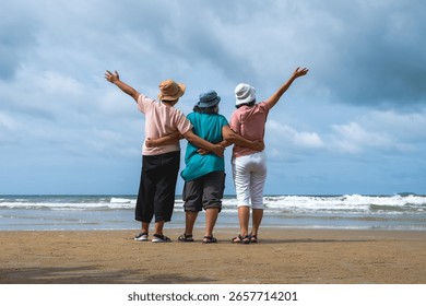 Back view three elderly classmate friend women standing and relax at beach during summer vacation