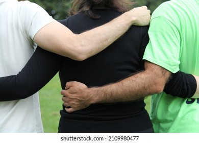 Back View Of Three Friends, One Girl And Two Boys, Hugging To Each Other With Love