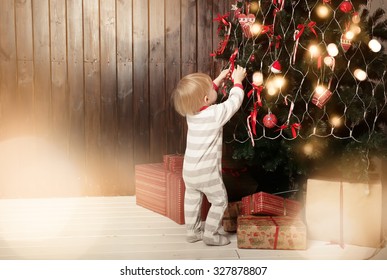 Back view of toddler boy decorating Christmas tree