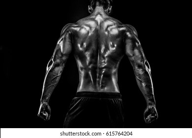 The Back View Of Torso Of Attractive Male Body Builder On Dark Background.