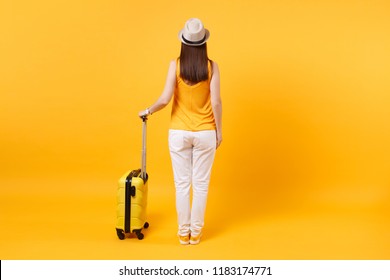 Back View Tourist Woman In Summer Casual Clothes, Hat With Suitcase Isolated On Yellow Orange Background. Female Passenger Traveling Abroad To Travel On Weekends Getaway. Air Flight Journey Concept