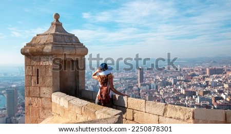 Back view of traveler girl in Alicante, Santa Barbara castle and panoramic city landscape view- Spain
