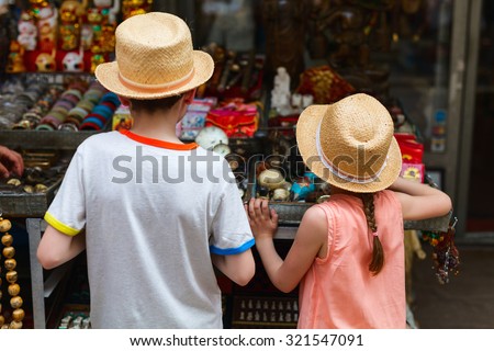 Back view of two kids brother and sister at flea market
