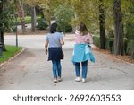 Back view of a two people having a walk outdoors in autumn
