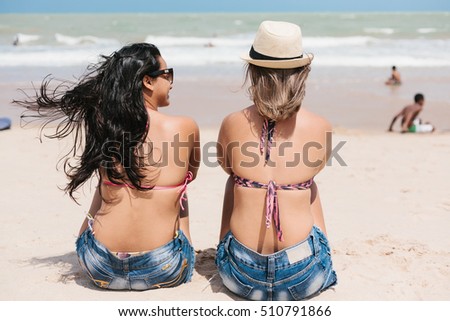 Back view of two women talking on the beach