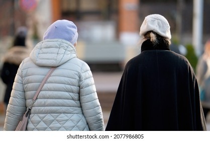 Back View Of Two Women Walking Away At Street.