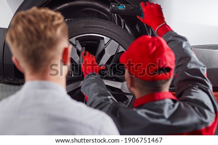 Similar – Image, Stock Photo Anonymous repairman examining car exhaust system in garage