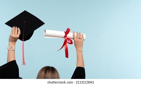 Back View Unrecognizable Woman Wearing Ceremony Robe Holding Certificate and Throwing Graduation Cap on Blue Background. Girl Celebrating Graduation and Getting Diploma. Graduate Cap and Degree Paper - Shutterstock ID 2113113041