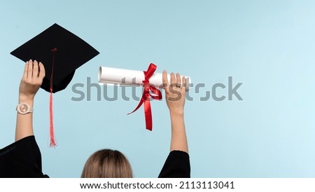 Back View Unrecognizable Woman Wearing Ceremony Robe Holding Certificate and Throwing Graduation Cap on Blue Background. Girl Celebrating Graduation and Getting Diploma. Graduate Cap and Degree Paper