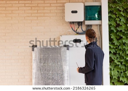 Back view of unrecognizable young man technician installing a solar system for renewable energy