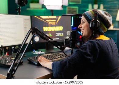 Back View Of Upseted Streamer Playing Game Competition Using Professional Setup With Streaming Chat Open. Gamer Sitting On Gaming Chair Using Wireless Controller And Professional Headphone