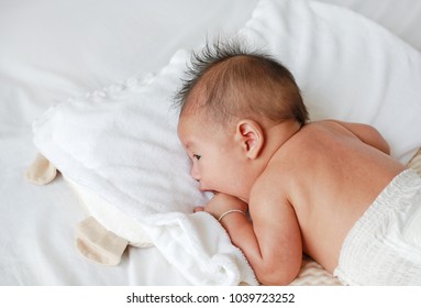 Back view upside down of infant baby lying on the bed.