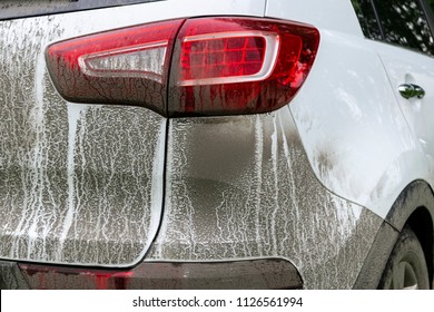 Back View Of A Very Dirty Car. Fragment Of A Dirty SUV. Dirty Headlights, Wheel And Bumper Of The Off-road Car With Swamp Splashes On A Side Panel