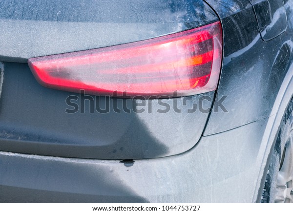 Back view of a very dirty car. Fragment of a\
dirty SUV. Dirty rear lights, wheel and bumper of the off-road car\
with swamp splashes on a side\
panel