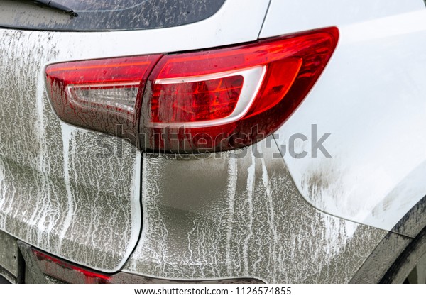 Back view of a very dirty car.
Fragment of a dirty SUV. Dirty headlights, wheel and bumper of the
off-road car with swamp splashes on a side
panel