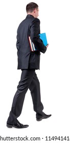 Back View Of Walking  Business Man With Books. Going Young Guy In Black Suit. Isolated Over White Background. Rear View People Collection. Backside View Of Person